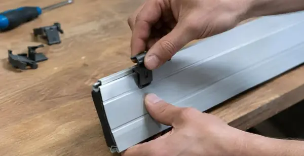 Gros plan sur des mains qui fixent une attache neuve sur la lame d'un tablier posé sur une table